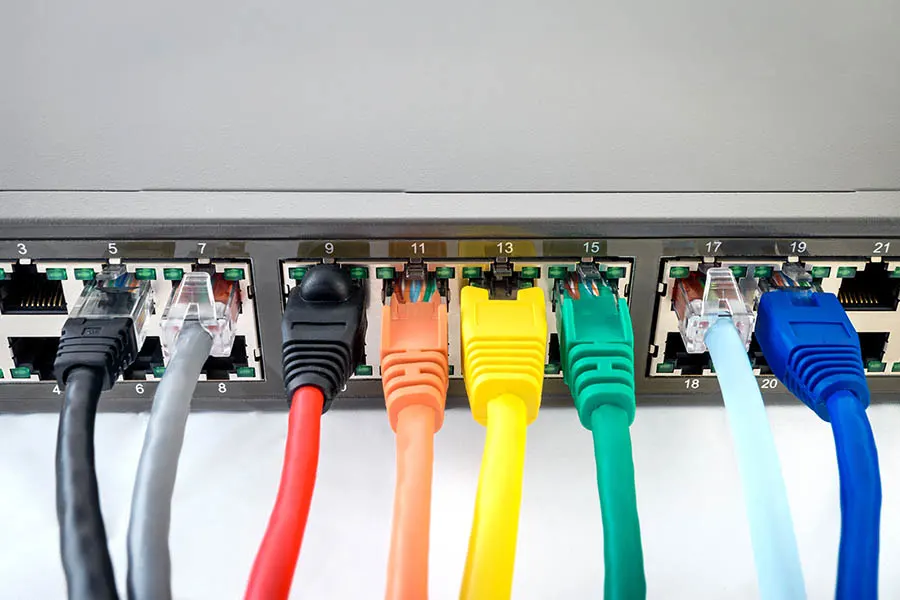 Network switch with various colored ethernet cables connected to it