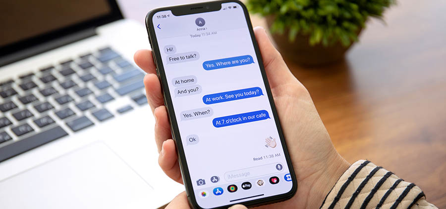 Woman holding iPhone X with iMessages Open