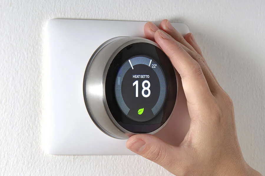 Smart Thermostat with a hand in frame