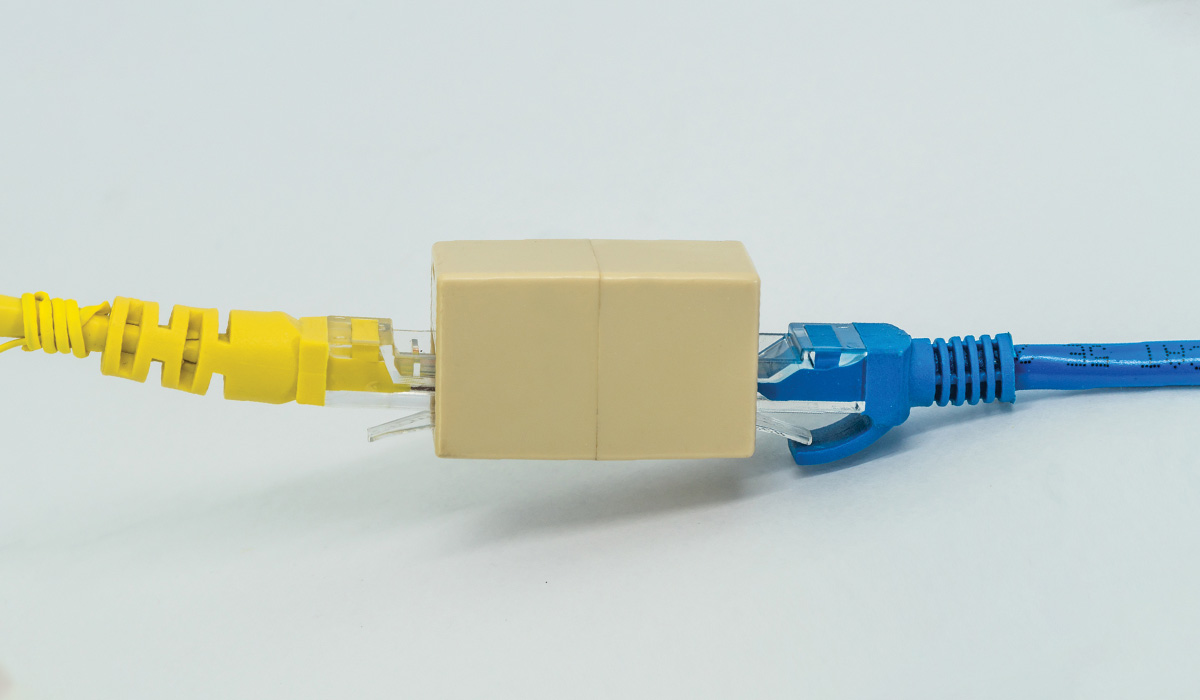 Blue and Yellow ethernet cables pluged into RJ45 cable extender coupler