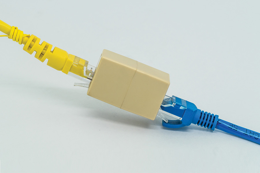 Blue and Yellow ethernet cables pluged into RJ45 cable extender coupler