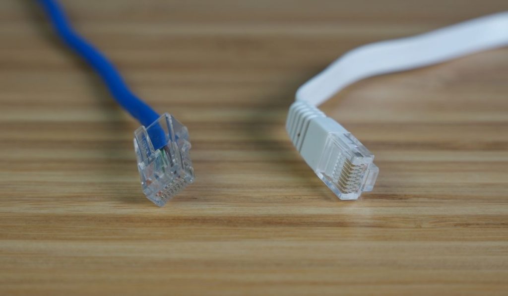 Плоский белый кабель Ethernet и круглый синий кабель Ethernet