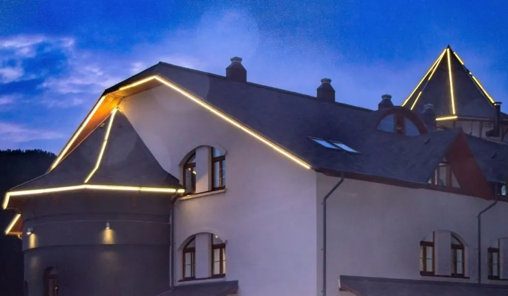 Luxury stylish mansion with a roof illuminated by led strips against a dark sky