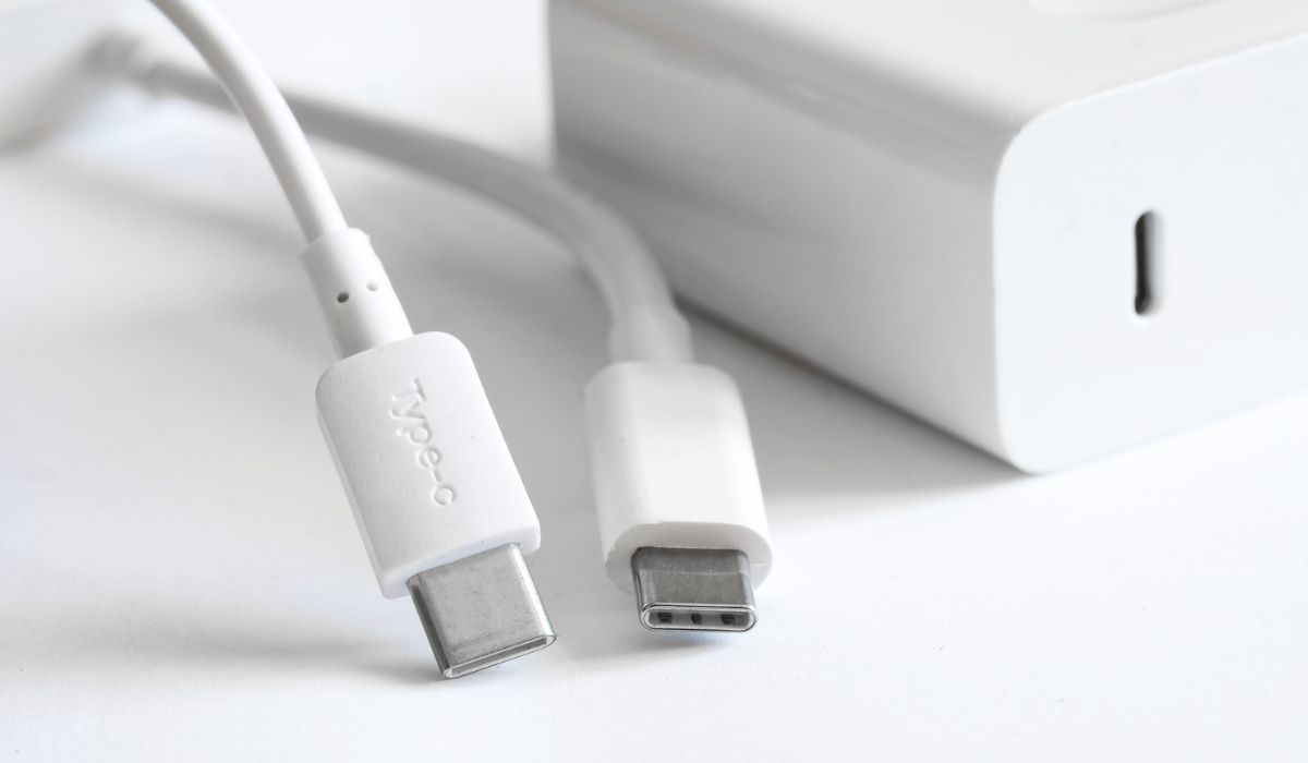Two white usb type-c connectors with wires lie on a light background