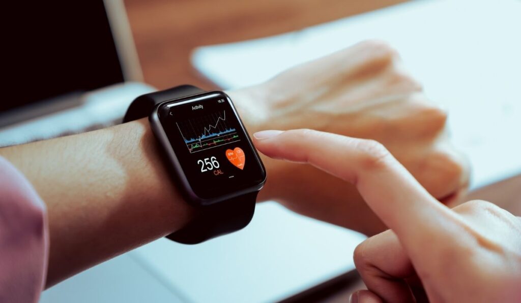 Close up of hand touching smartwatch with health app on the screen