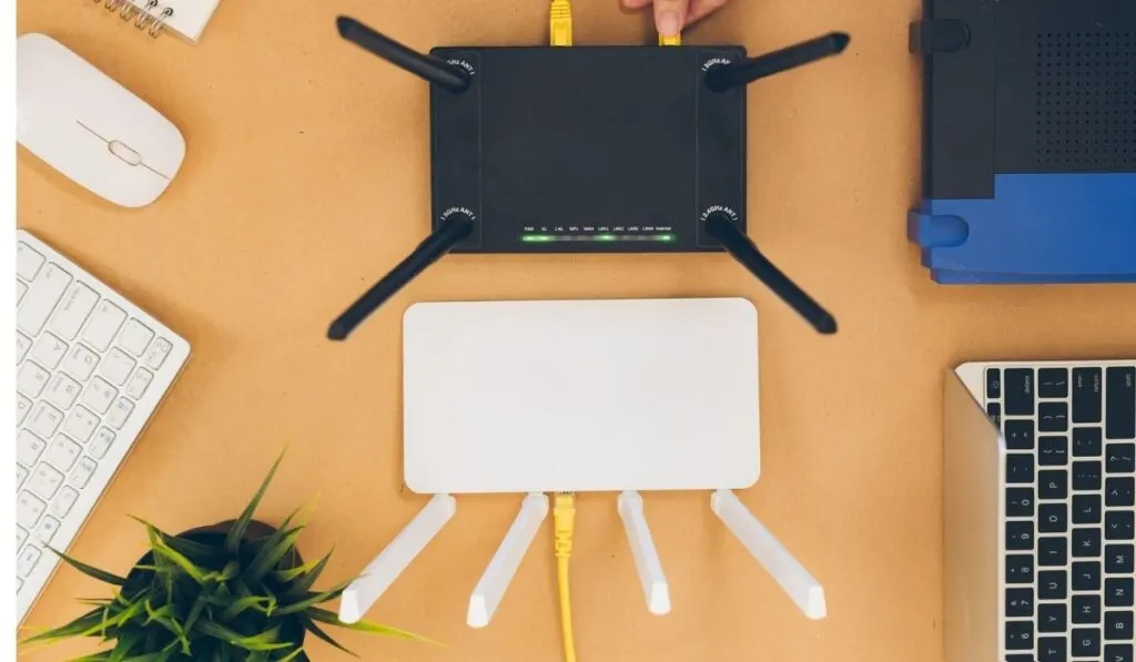 Flat lay Office table with wifi router, computer and supplies top view