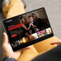 Man looking TV series and movies via streaming service on tablet