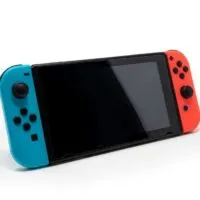 Hybrid video game console with switch detachable controllers on both sides