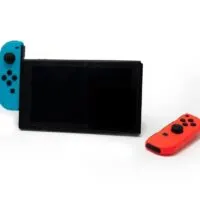 Hybrid video game console with switch detachable controllers on both sides