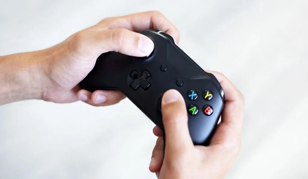 Black joystick in hands isolated on white background