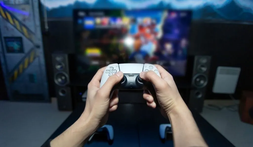 Close up of man hands holding wireless joysticks on foreground