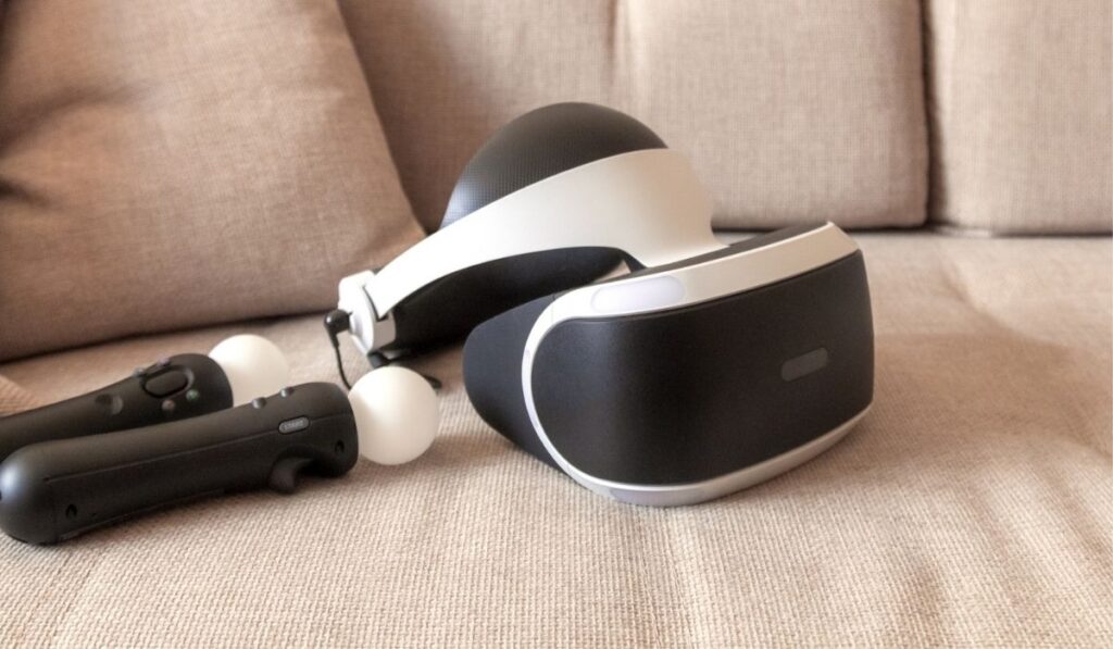 A playstation 4 VR headset together with a playstation 4 controller and two move controllers on