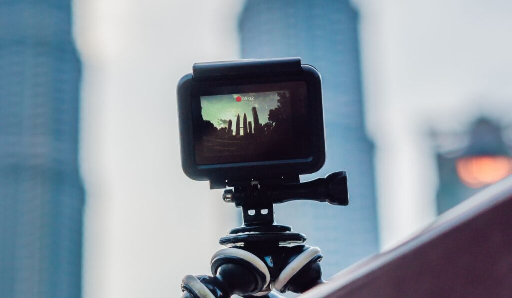 Экшн-камера на штативе записывает замедленное видео большого города -