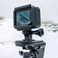 Action camera stands on a tripod against the backdrop of the mountains