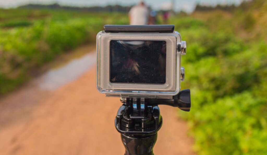 GoPro action camera on stick in dirt road at rural area
