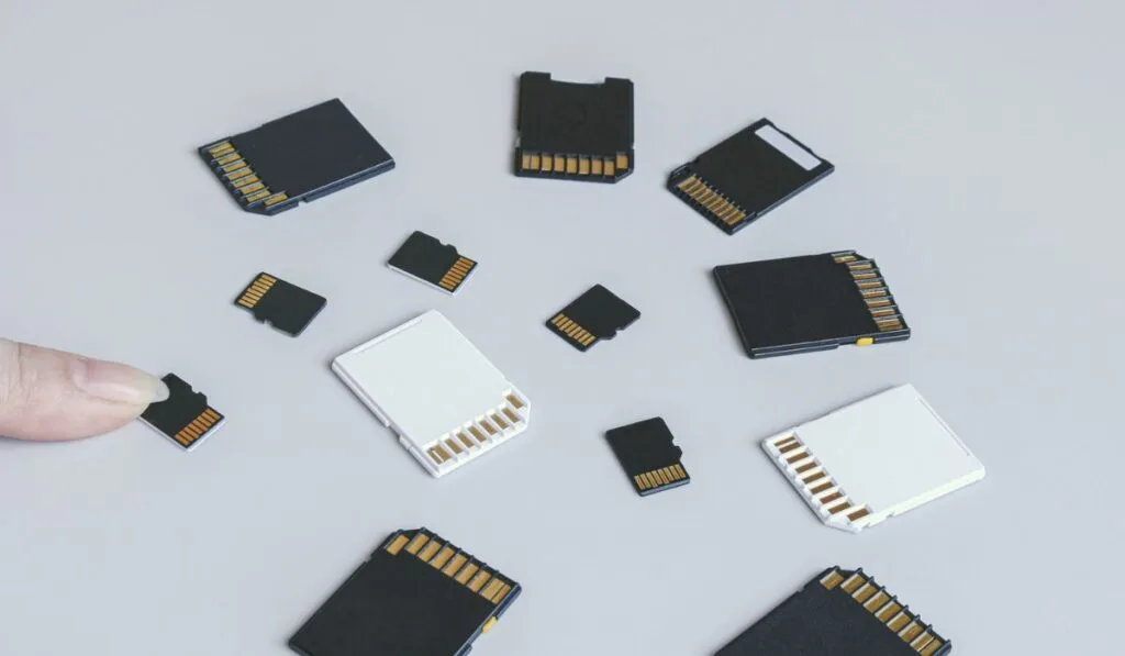 Scheda di memoria microSD e consegnare sullo sfondo di altre schede di memoria SD