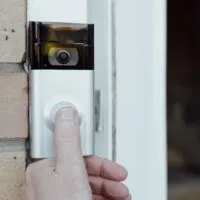Shallow focus of a homeowner seen testing a newly installed WiFi smart doorbell