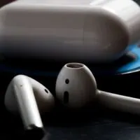 Airpod with charging case on wireless charger in low key lighting