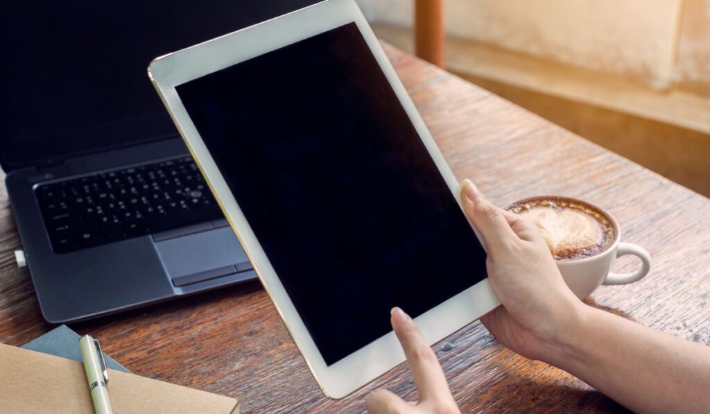 Close up hand woman using tablet in coffee shop