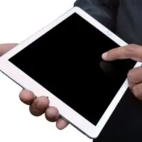 Man holding a tablet computer sideview
