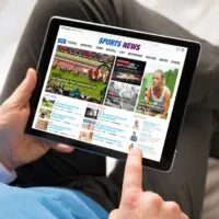 Man reading sports news on tablet