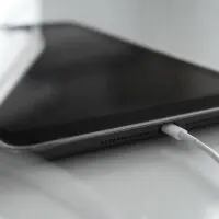Tablet charging on white table