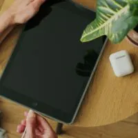 Woman hands plugging the charging cable in the port of a tablet device to charge the battery