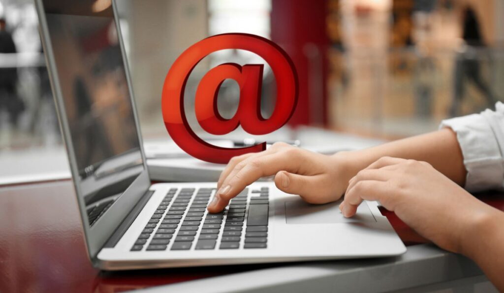 Женщина отправляет электронную почту через ноутбук в кафе