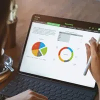 Woman using digital tablet third person view