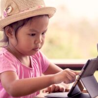 Asian little girl is playing ipad tablet