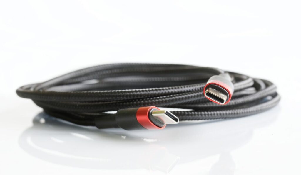 Black braided wire with two red-black usb type-c connectors on a light background 