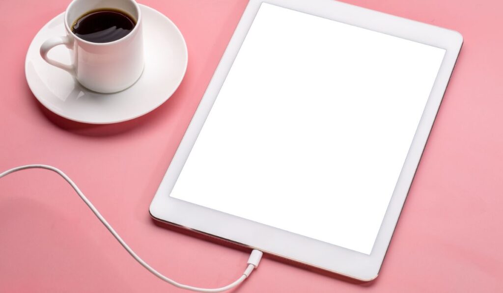 Digital tablet with blank screen on a pink background