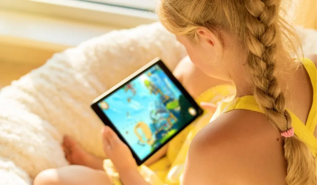 Girl playing game on tablet computer
