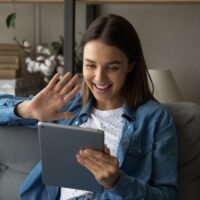 Happy young woman talk on video call on tablet