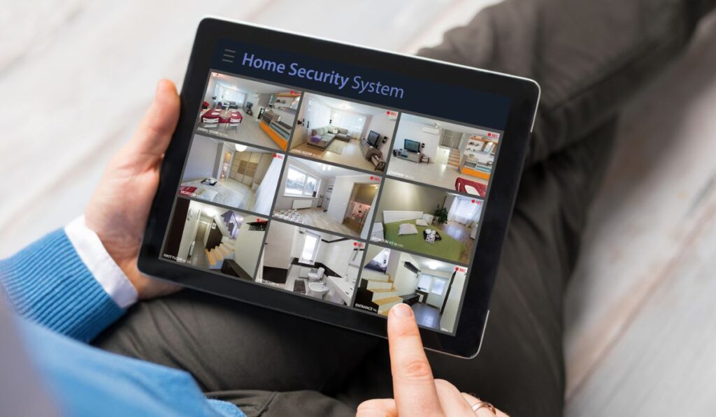 Man looking at home security cameras on tablet computer 