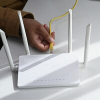 Man plugging in cable to wireless router
