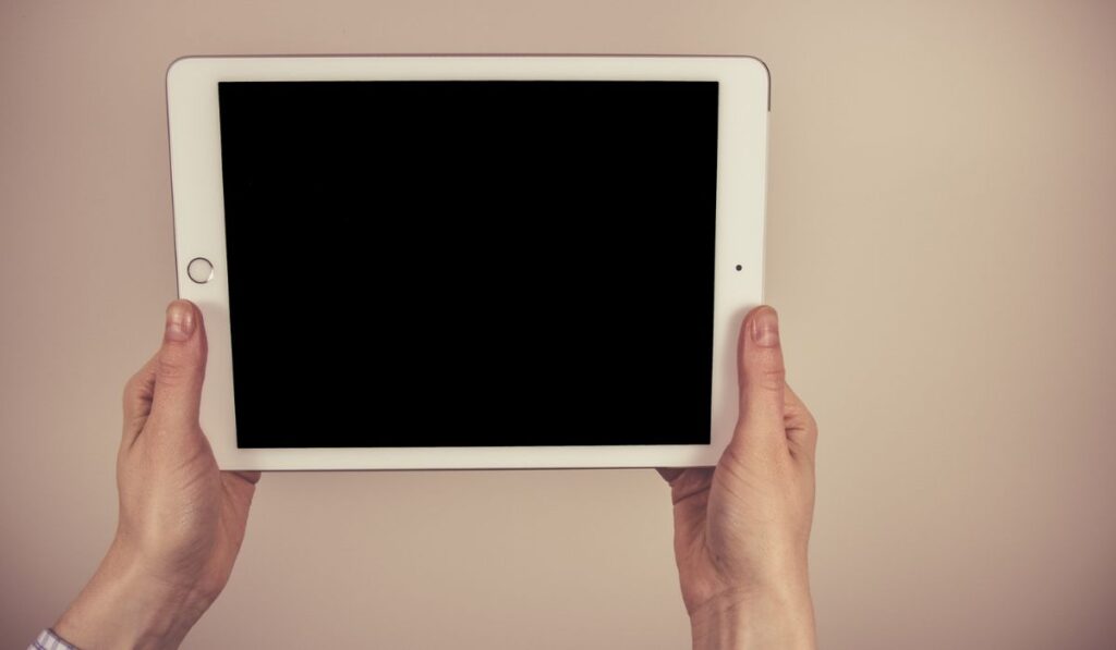 Woman hands holding and pointing on contemporary digital frame with blank screen 