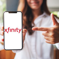 Woman holding phone with Xfinity on it