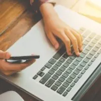 Businessmen are using their mobile to work with a laptop