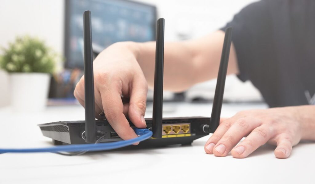 Man connects the internet cable to the router