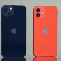 Midnight iPhone 13 and Product Red iPhone 12 standing