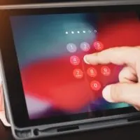 Hand of business man tying tablet computer with password login on screen at office
