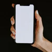 Woman's hand holding phone with blank screen