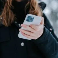 A woman holding an iphone 12