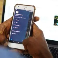 Blackman using Twitter mobile app ft Computer