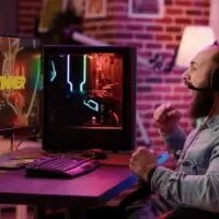 Handheld shot of streamer doing victory hand gesture after win in action video game