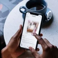 Person Holding White Printer Paper Near Black Ceramic Mug With Coffee