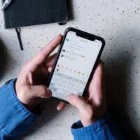 Person in Blue Denim Jacket Holding Black Smartphone