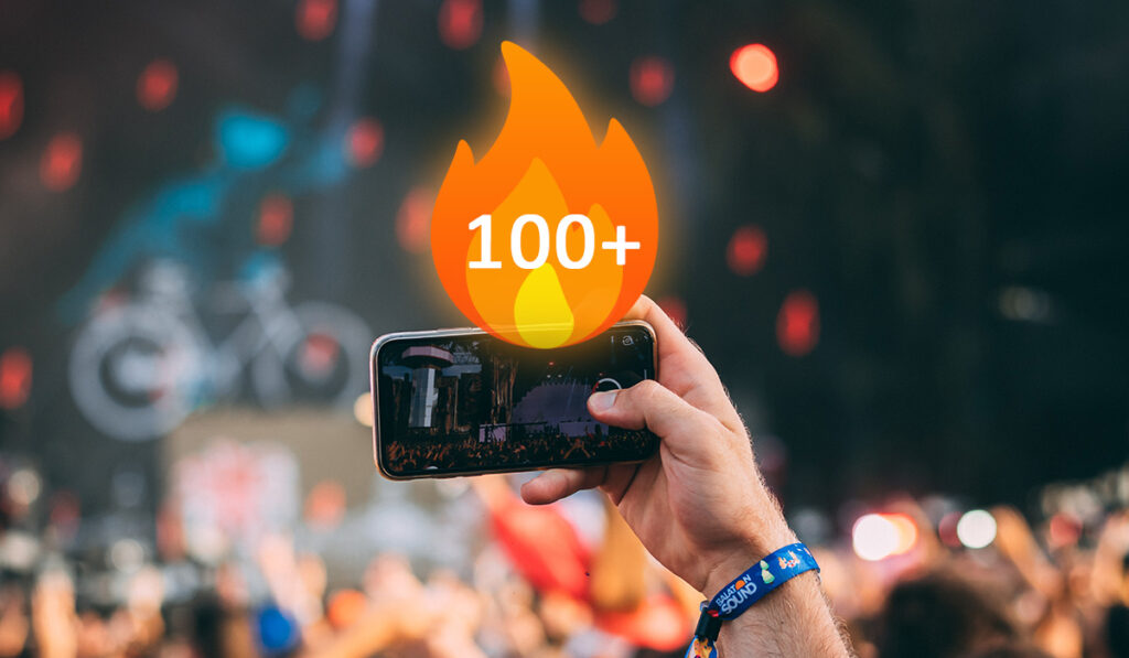 Phone recording concert with fire emoji showing 100+ on it
