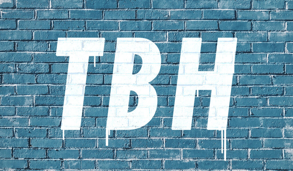 TBH sprayed on a blue brick wall